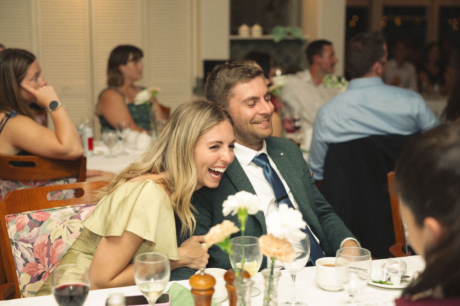 Smiling couple shares a joyful moment together at elegant wedding reception dinner.