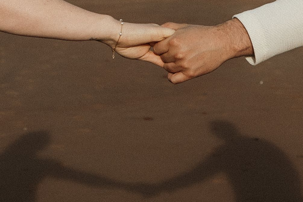 Close-up shot of hands holding a traditional clay pot with a dark rustic background.