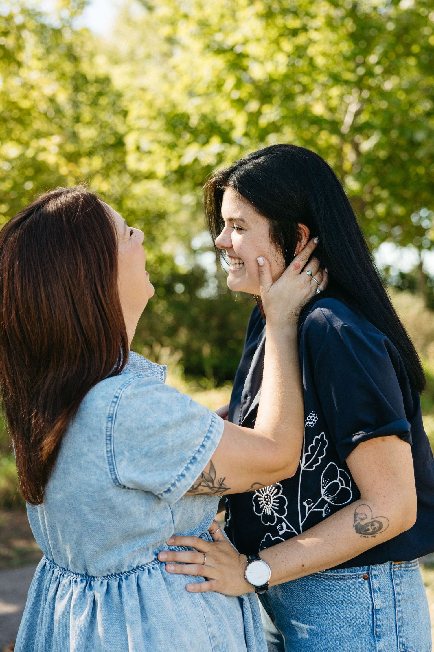 Couple sharing an intimate moment outdoors on a sunny day.
