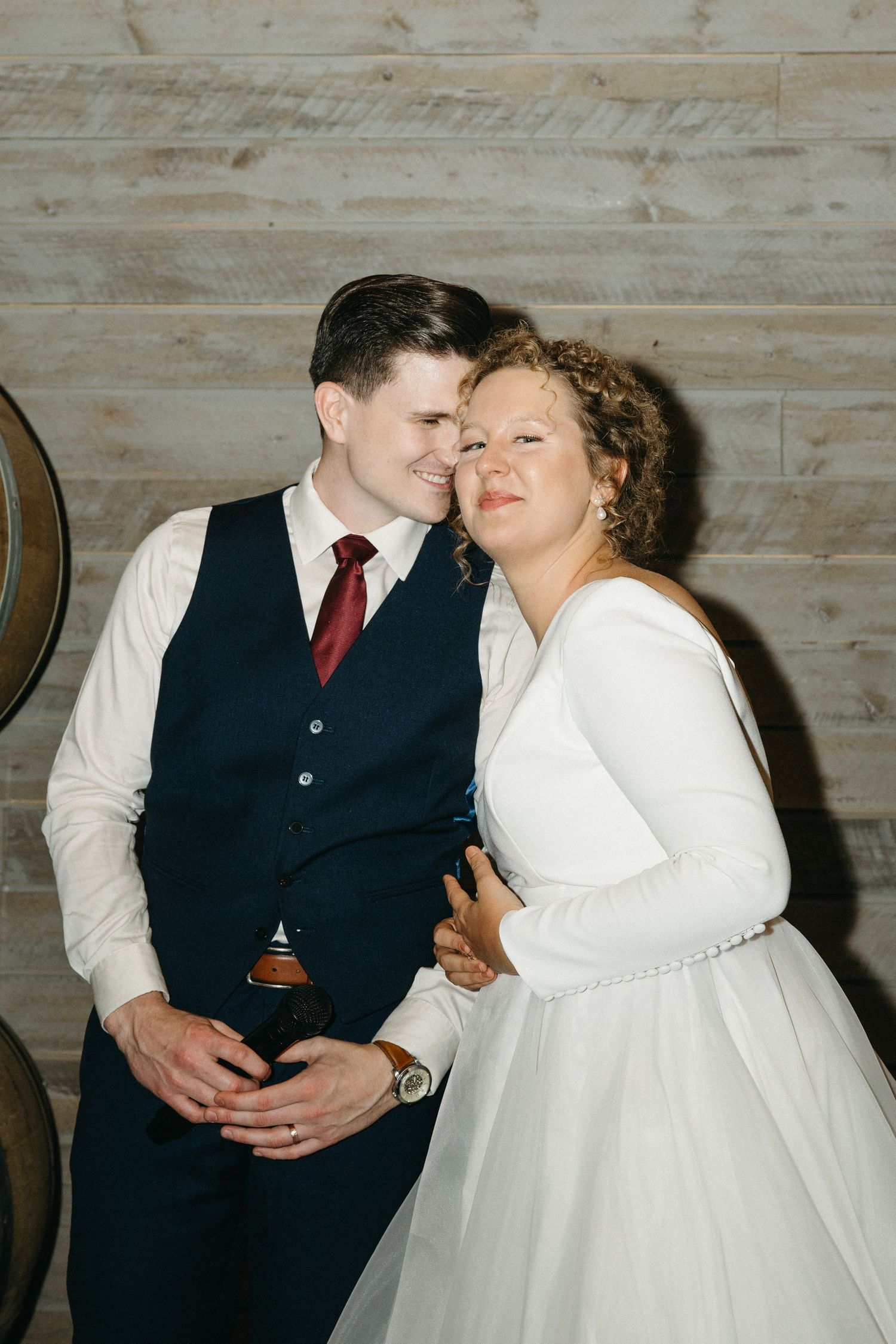 Romantic wedding couple moment against rustic wooden wall background.