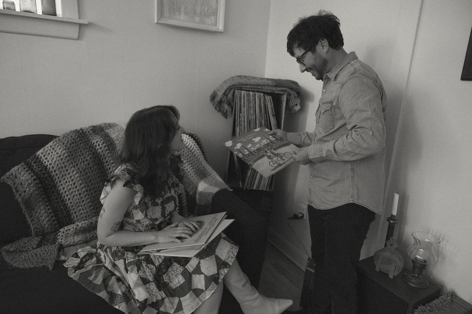 Black and white photo of couple reading books together with cats.