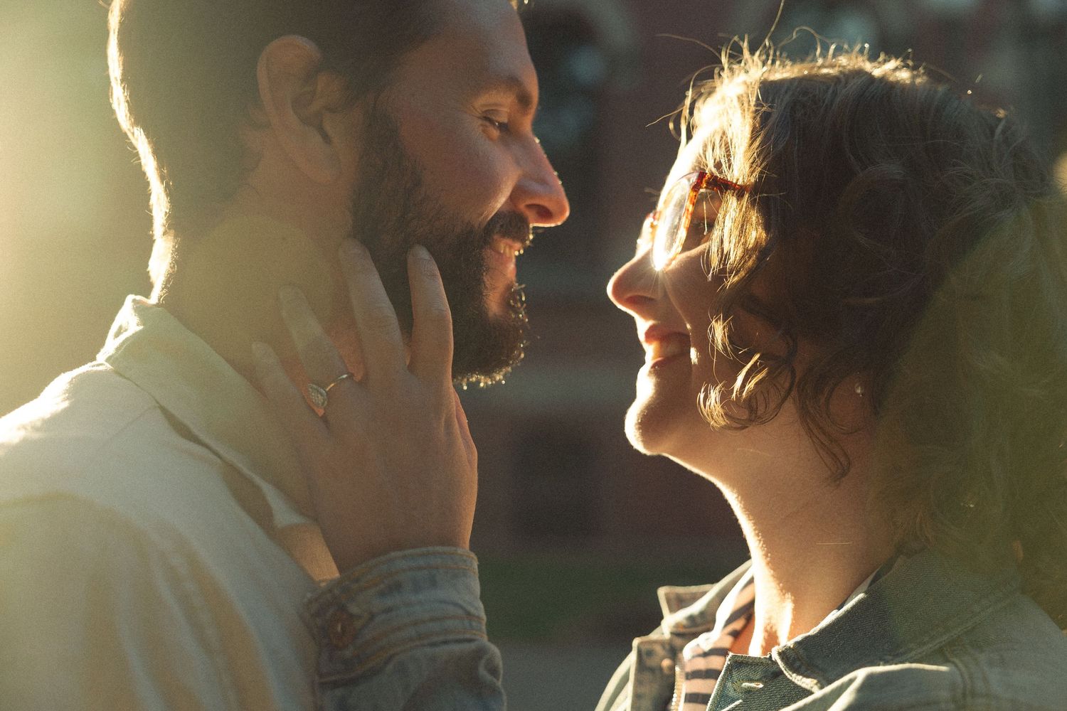 Two people share a tender embrace in golden evening light.
