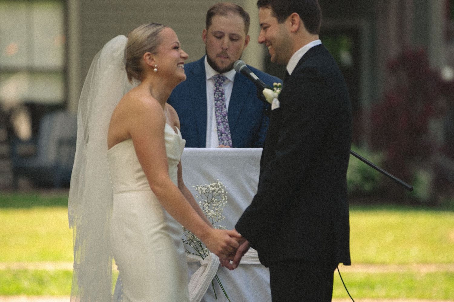 Intimate wedding ceremony moment under a covered outdoor structure.