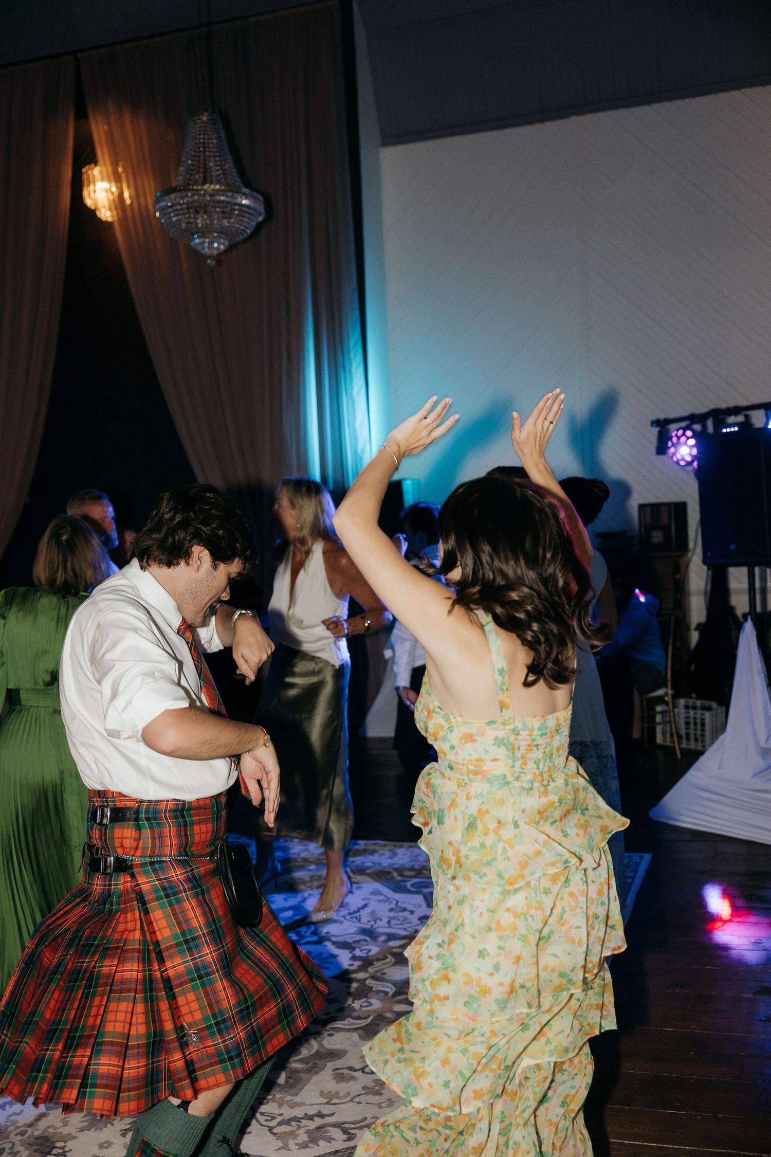 Dancers in traditional kilts and floral dresses enjoying a lively celebration.
