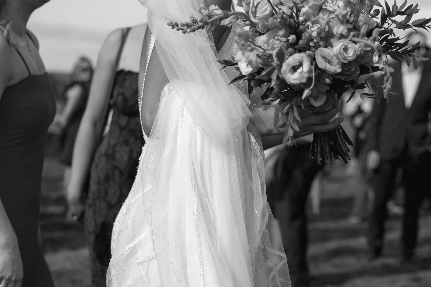 Elegant floral arrangements with pink and white blooms decorate the outdoor wedding space.