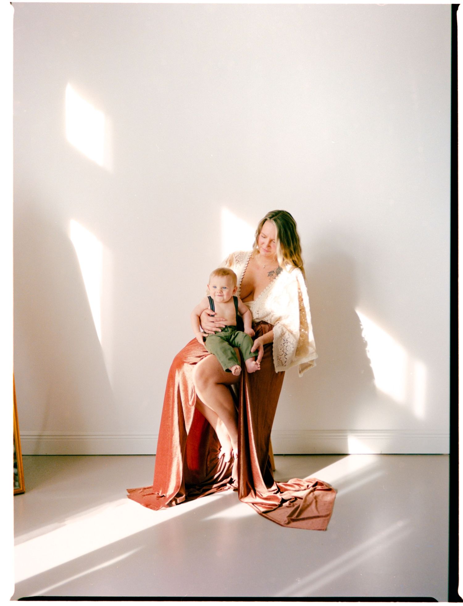 A series of artistic photographs showing figures in warm sunlight against a white wall creating dramatic shadows.