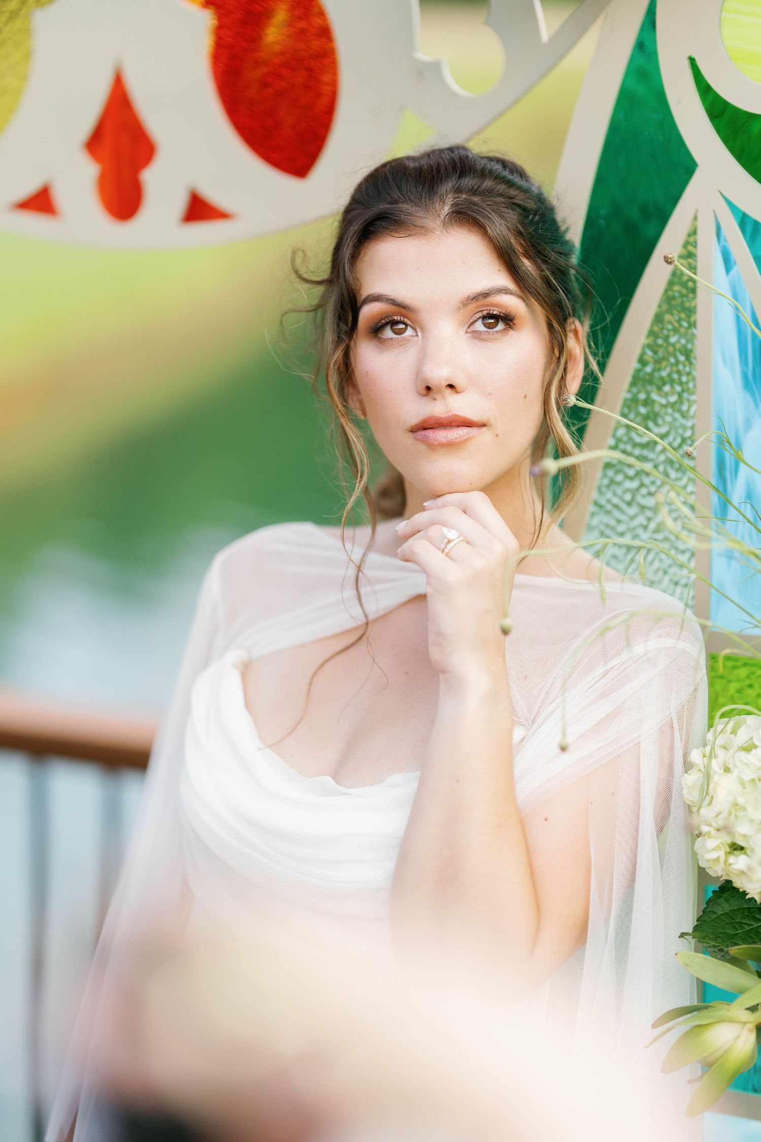 A dreamy bridal portrait with soft lighting and decorative elements in green and white tones in the background.