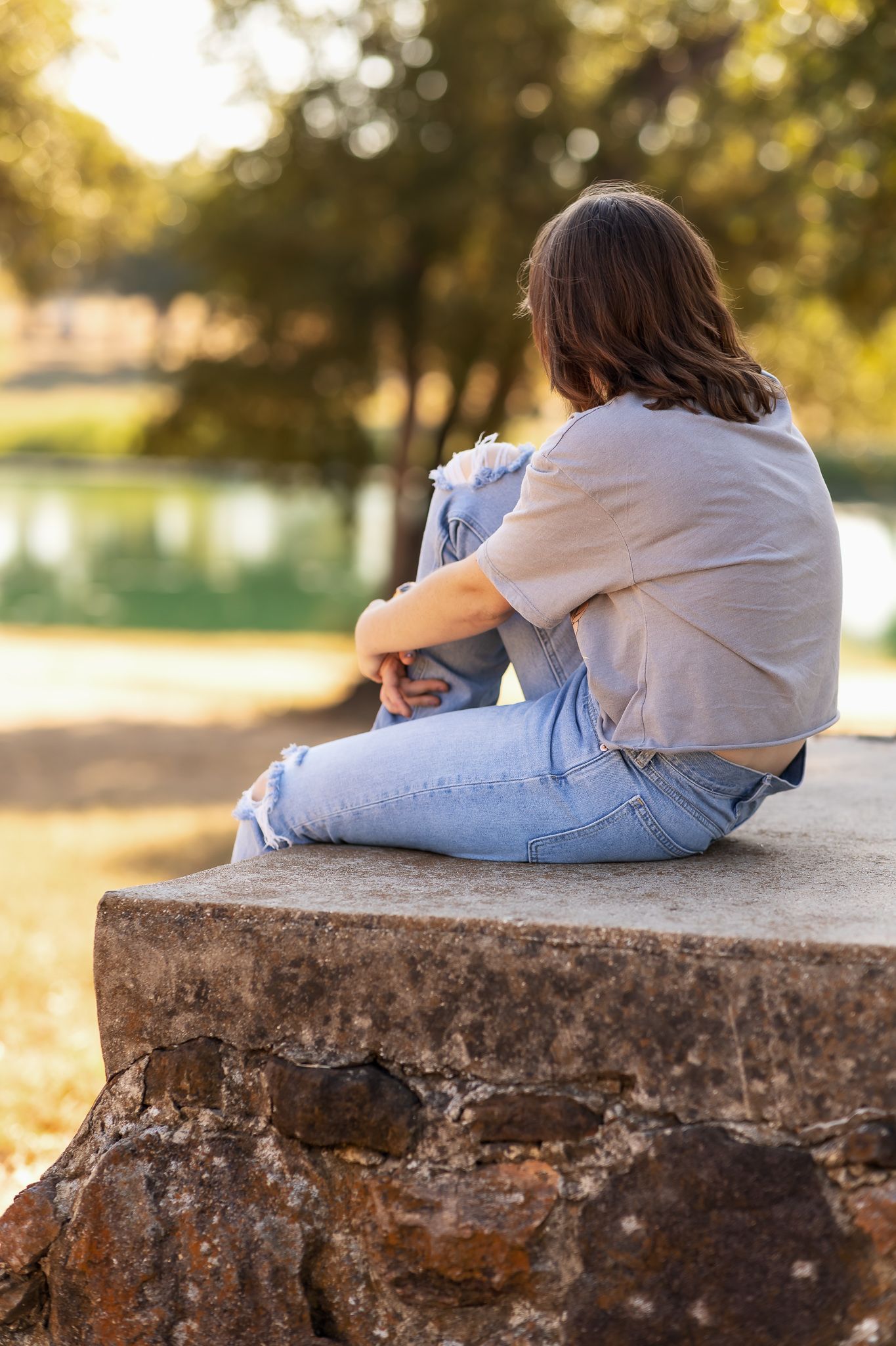 Outdoor portrait of individual sitting near pond