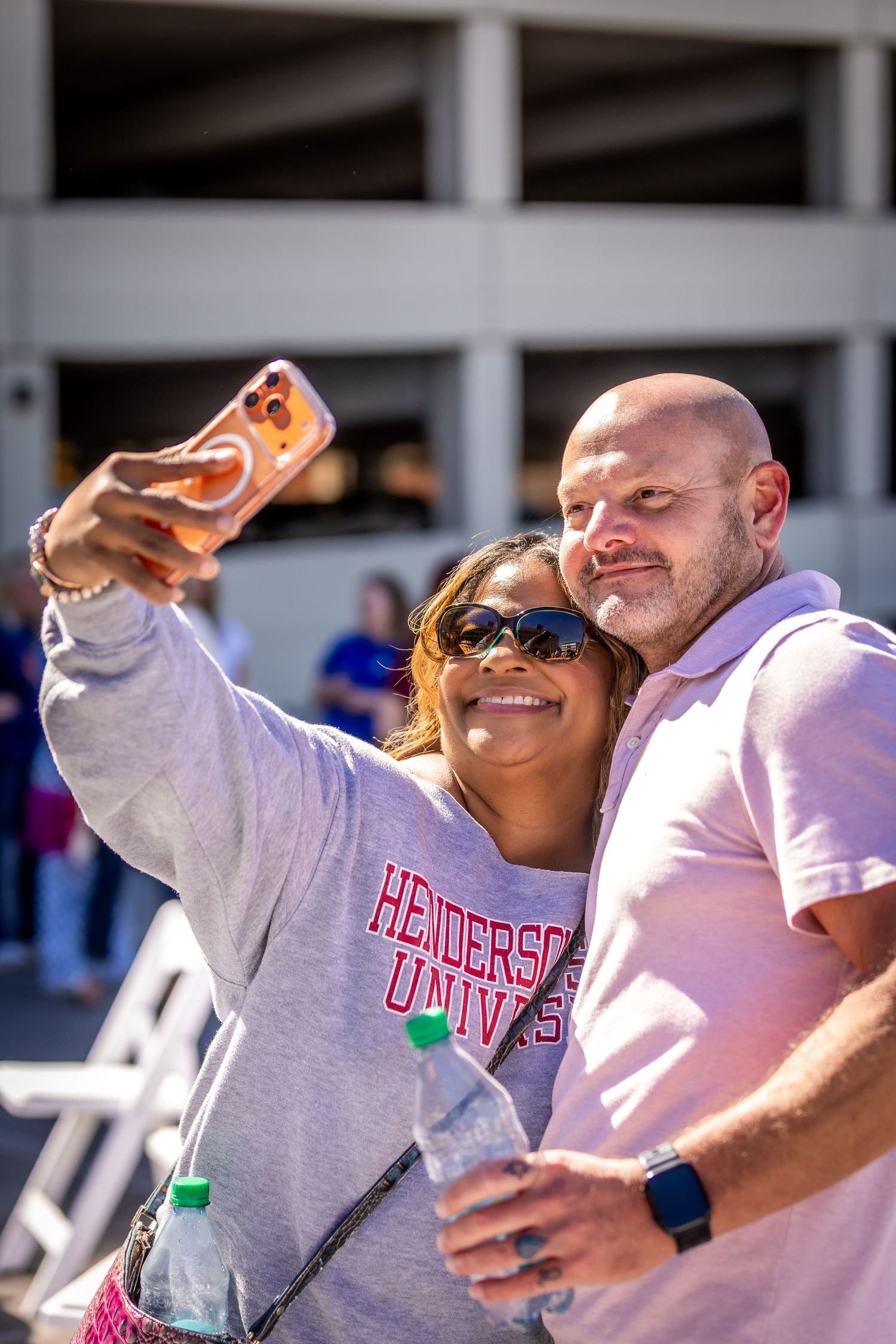 Group of enthusiastic supporters cheering and celebrating at an outdoor event.