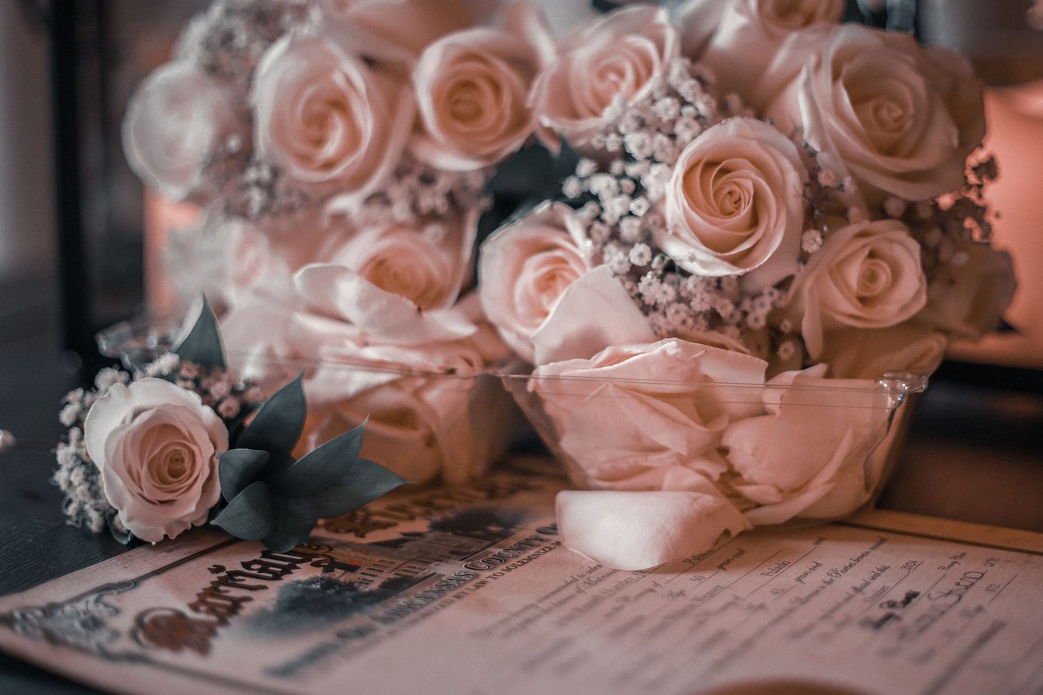 Delicate pink roses arranged alongside handwritten notes and vintage paper create a romantic and nostalgic composition.