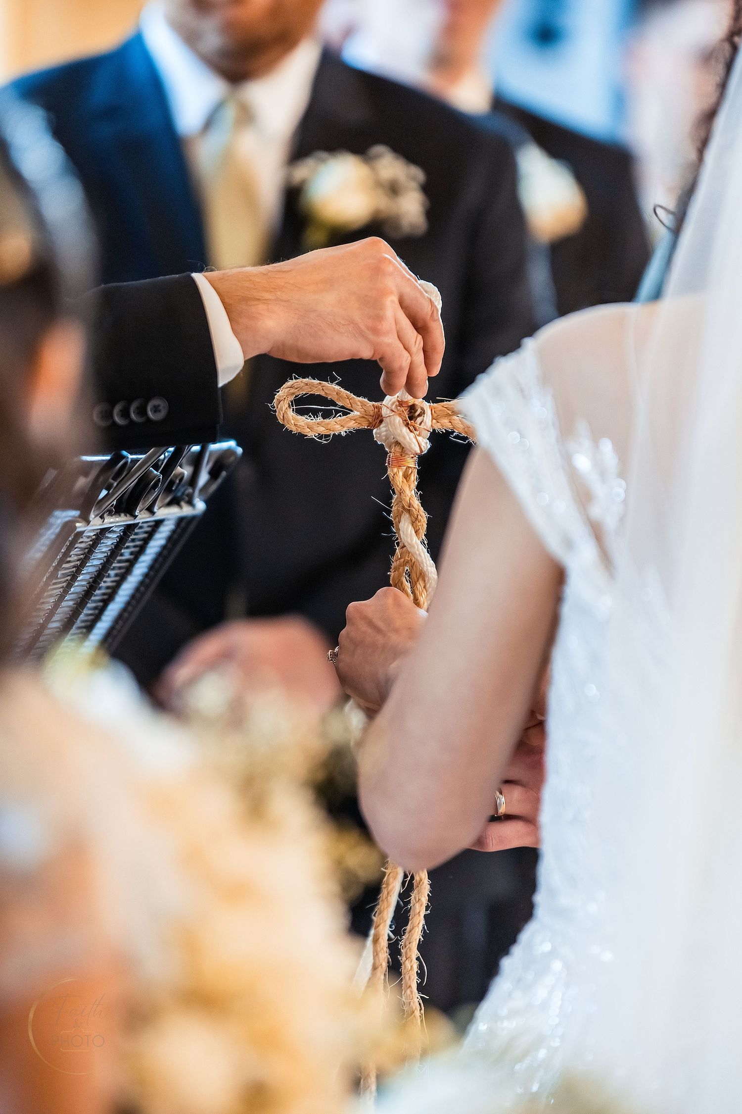 Bride and groom tying a unity knot with rustic twine rope during a wedding ceremony.