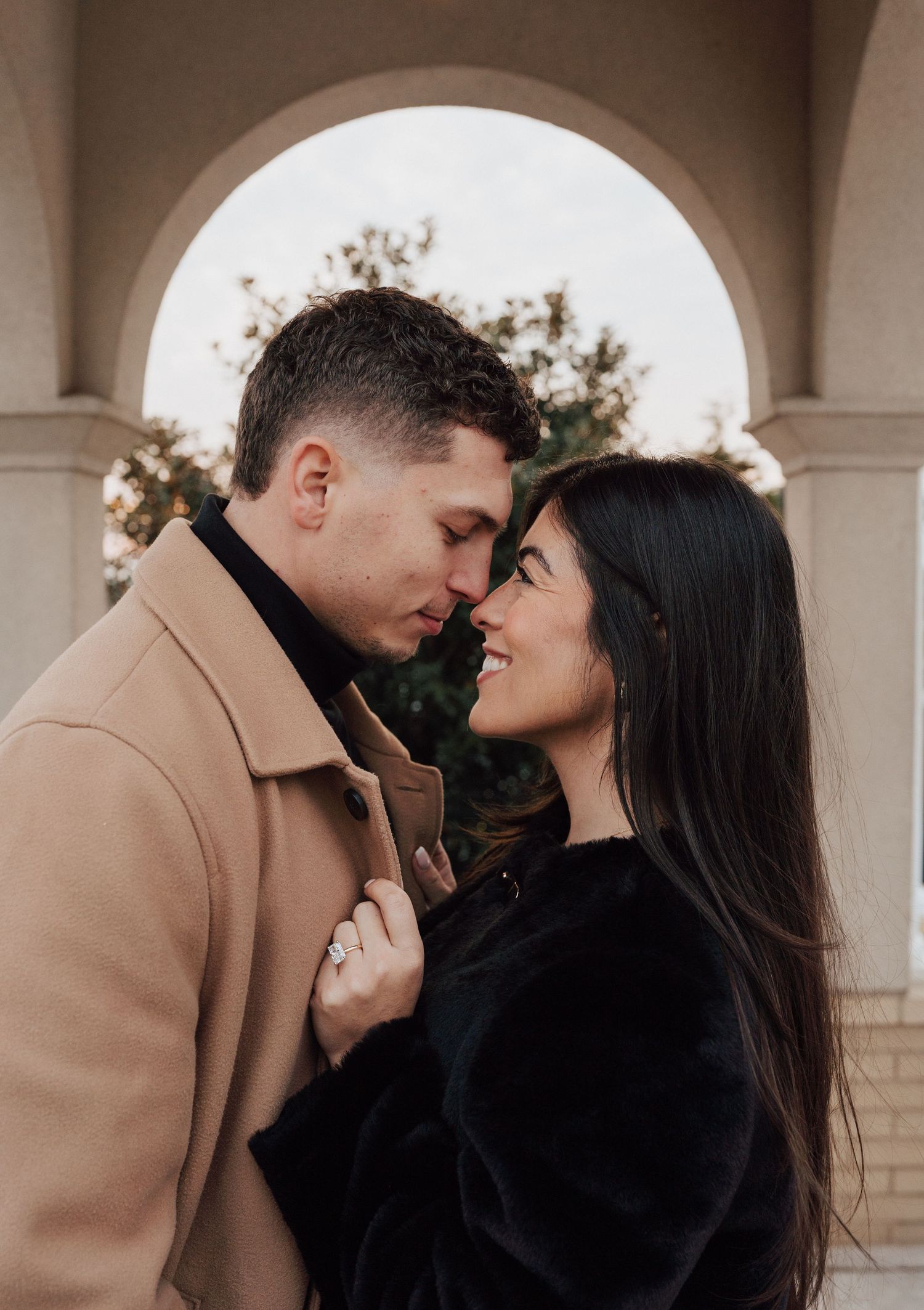 A romantic couple in contrasting beige and black outfits share intimate moments for engagement photoshoot at the Hershey Hotel in Hershey,PA