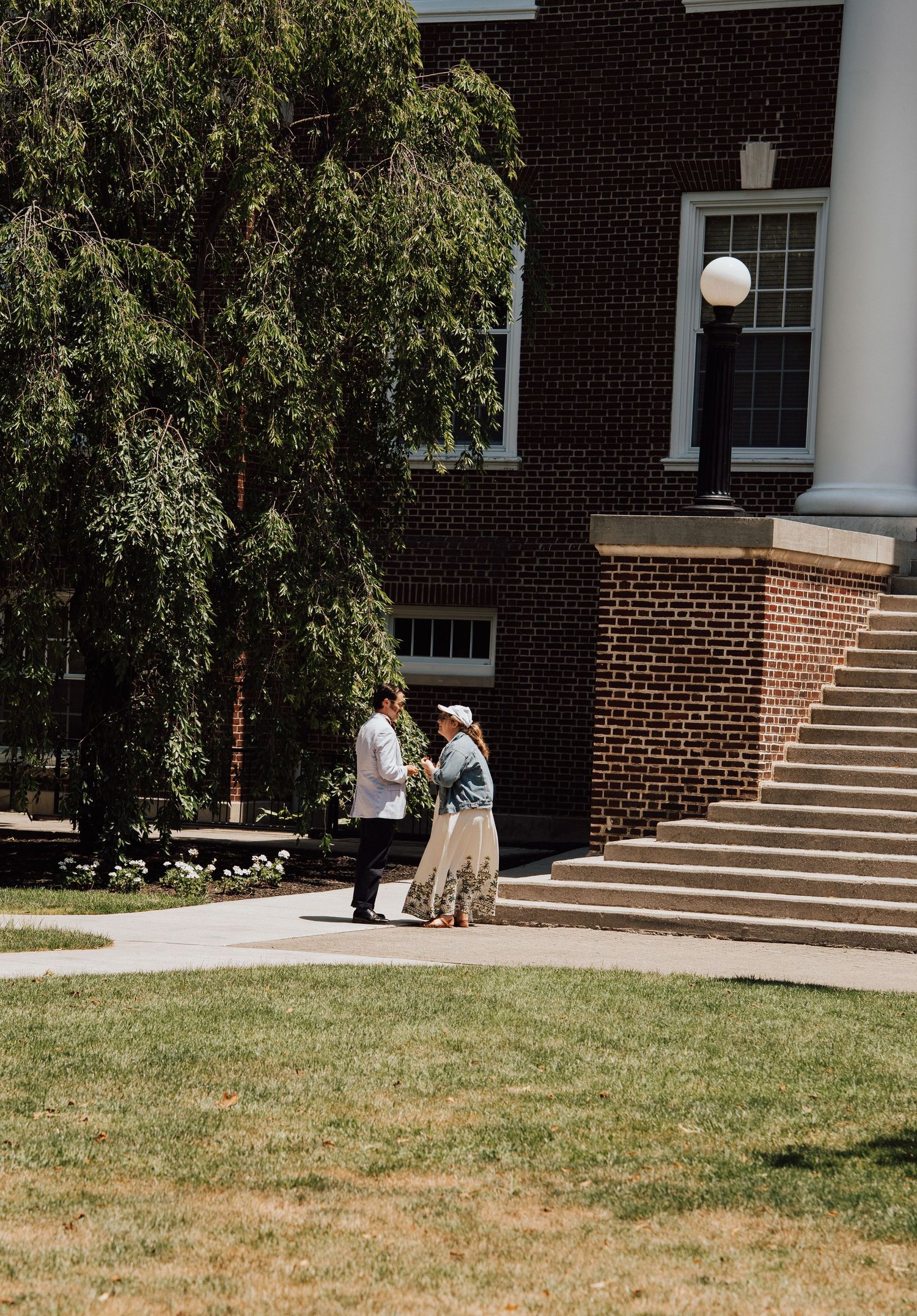 happy couple standing in front of building in Gettysburg College, PA after engagement proposal.
