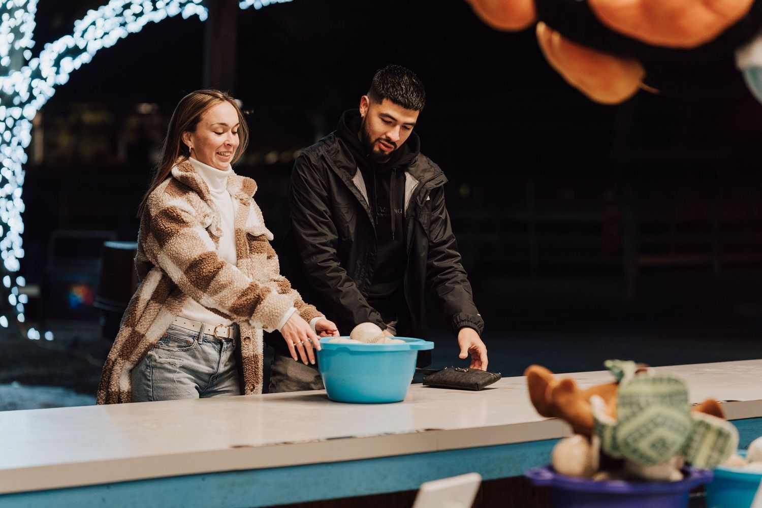 Engaged couple playing with baseball at Hershey Park for engagement proposal photoshoot.