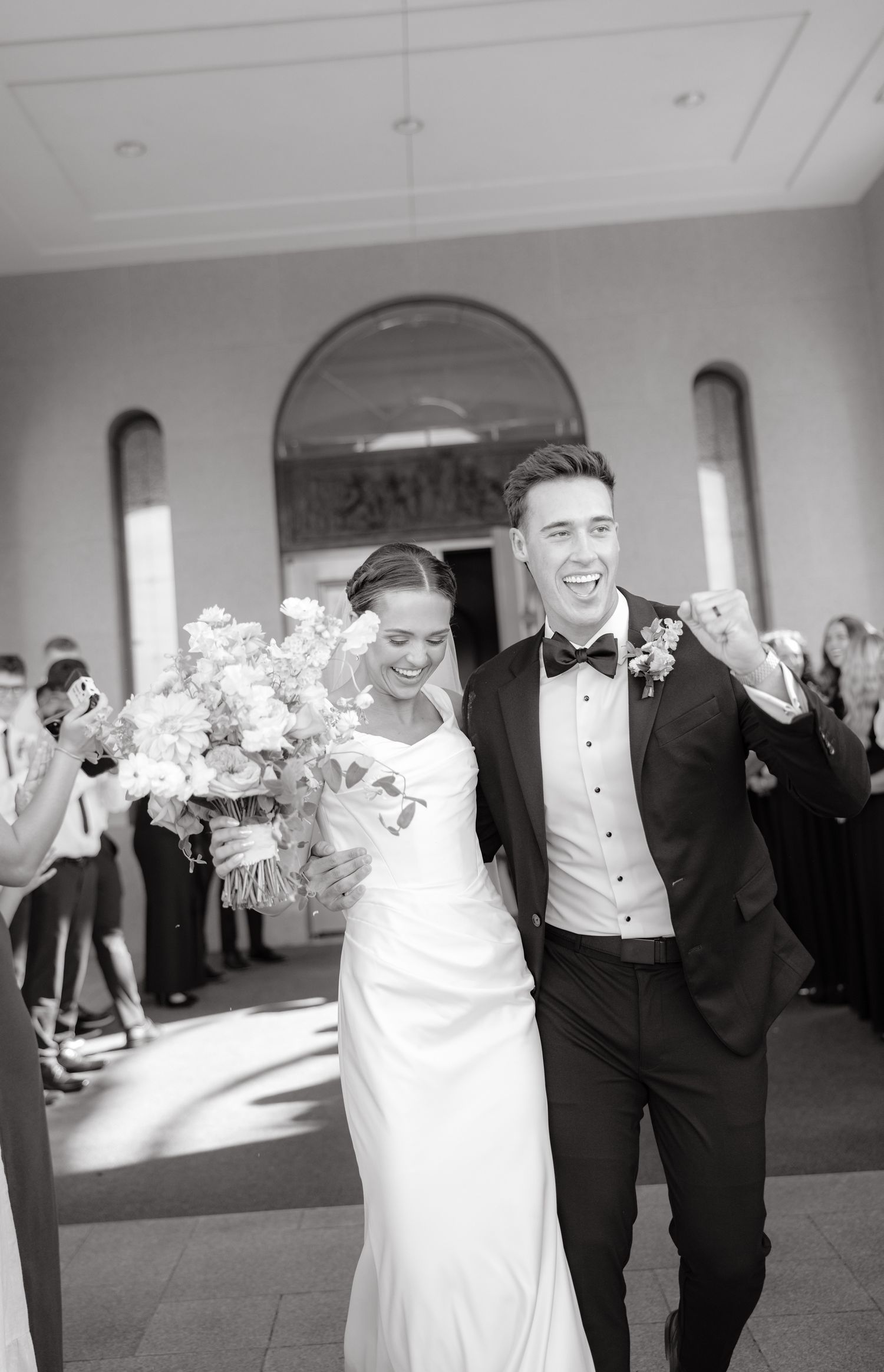 A black and white sequence of wedding party members dancing and celebrating together at a reception.