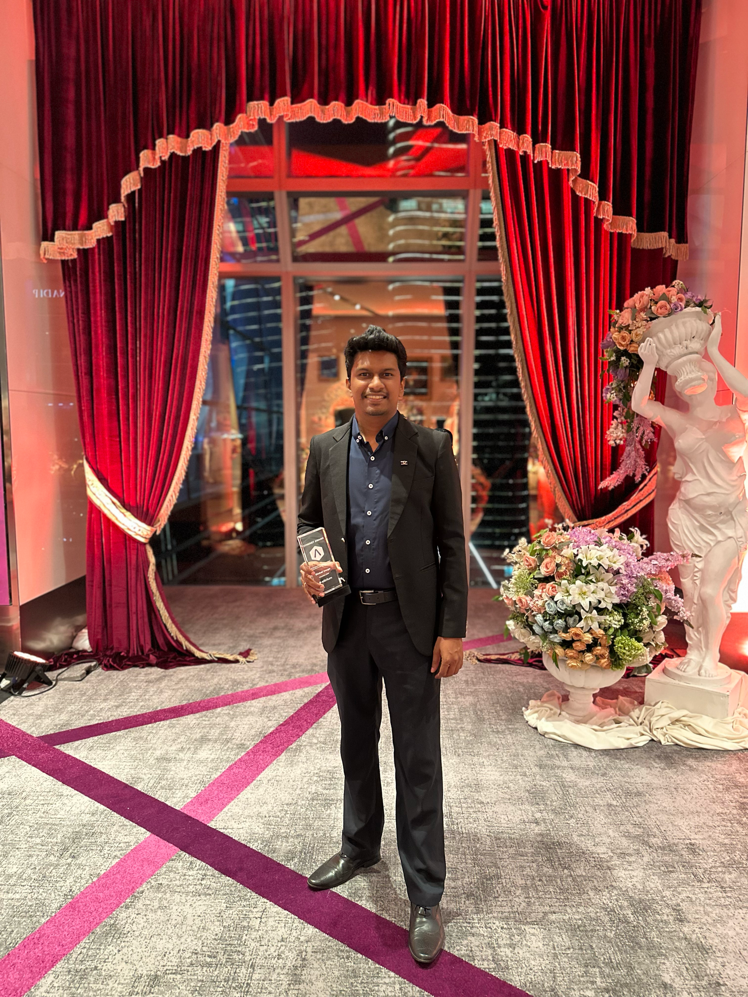 Event venue setup with red curtains and pink floor markings for special occasion.