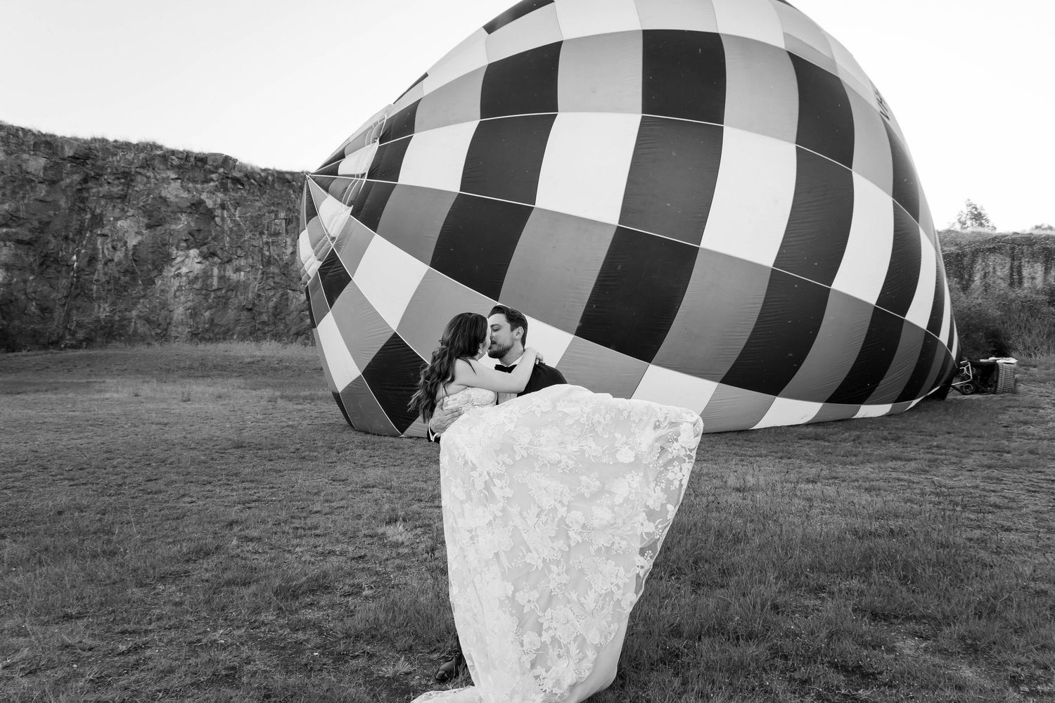 A black and white buffalo plaid blanket is captured in motion as it floats through a grassy field on an autumn day.