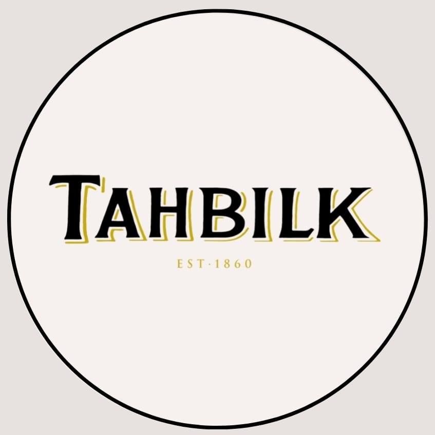 A circular white logo featuring the text 'TAHBILK EST. 1860' in black letters with yellow shadowing.