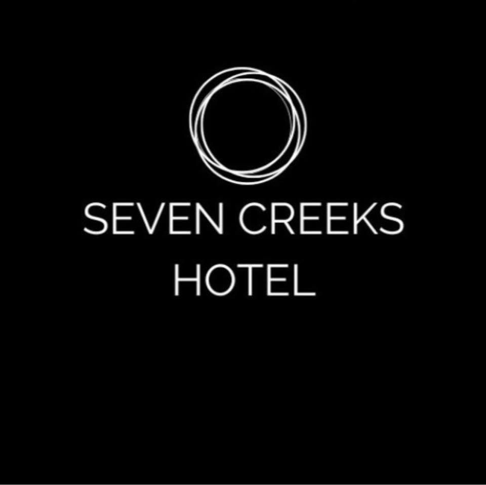 A minimalist logo design for Seven Creeks Hotel featuring circular elements on a black background.