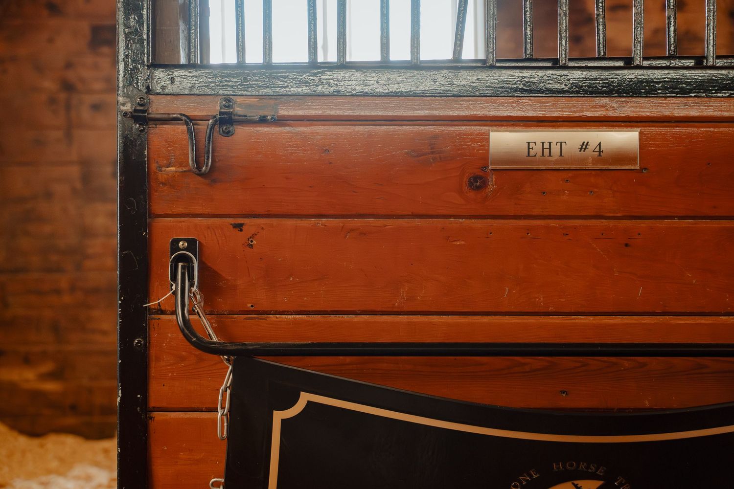 A row of vintage wooden filing cabinets with brass handles and labels mounted on a wall.