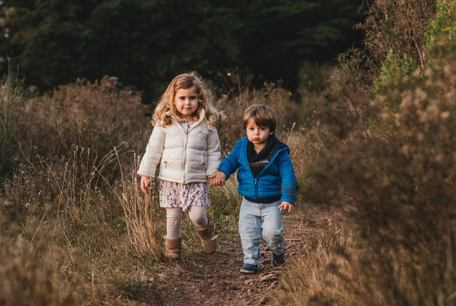 Los hijos de Vale Otero caminando de la mano durante el atardece de invierno r en Tandil