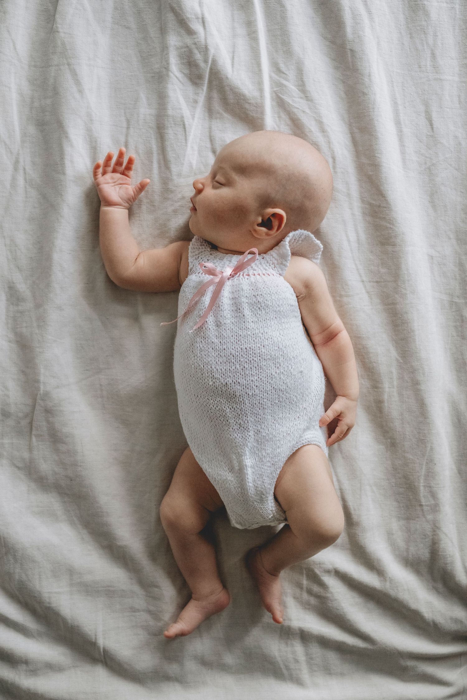 Bebé recién nacido durmiendo plácidamente sobre la cama de sus padres