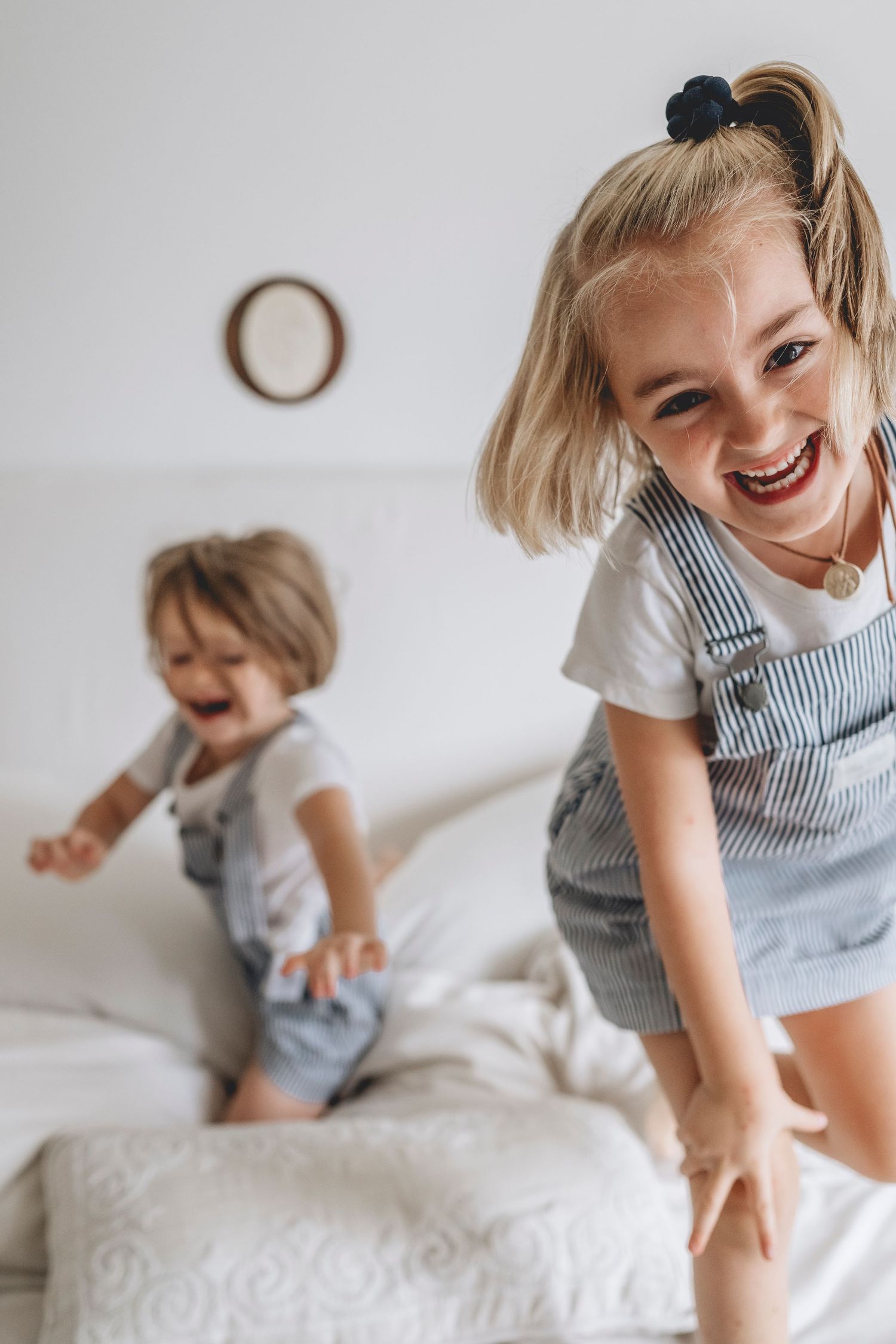 hermanas jugando y riendo en la cama de sus padres