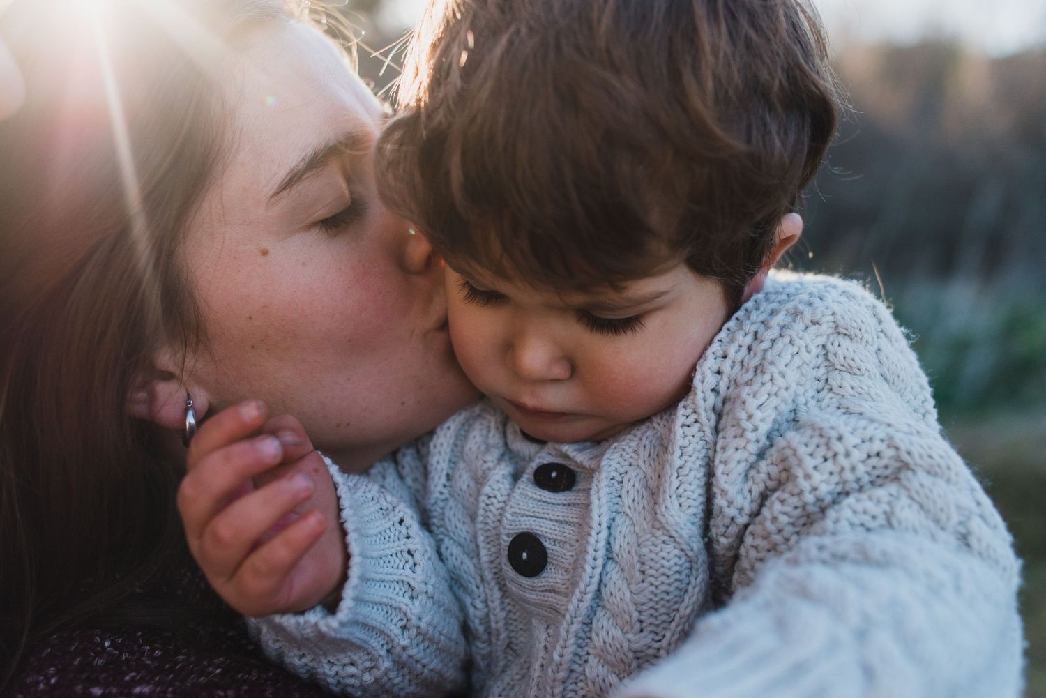 Mamá dándole un beso a niño de una año durante una sesión de fotos familiar en tandil