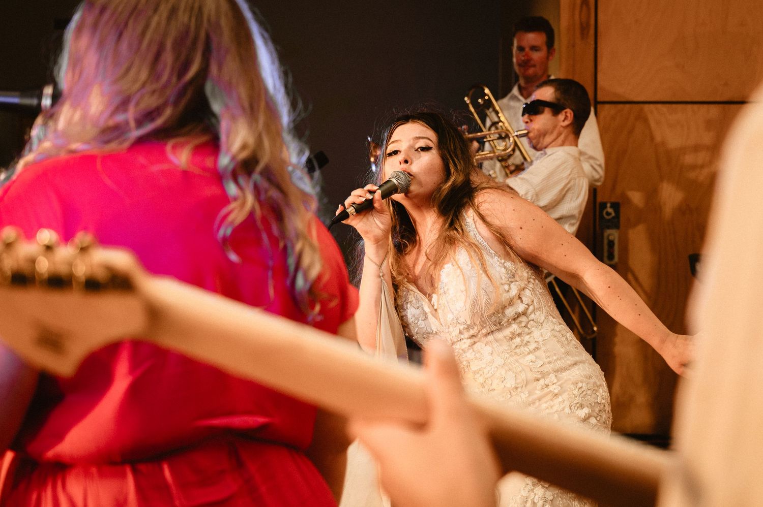 Wedding reception dance party with guests celebrating on a dimly lit dance floor.