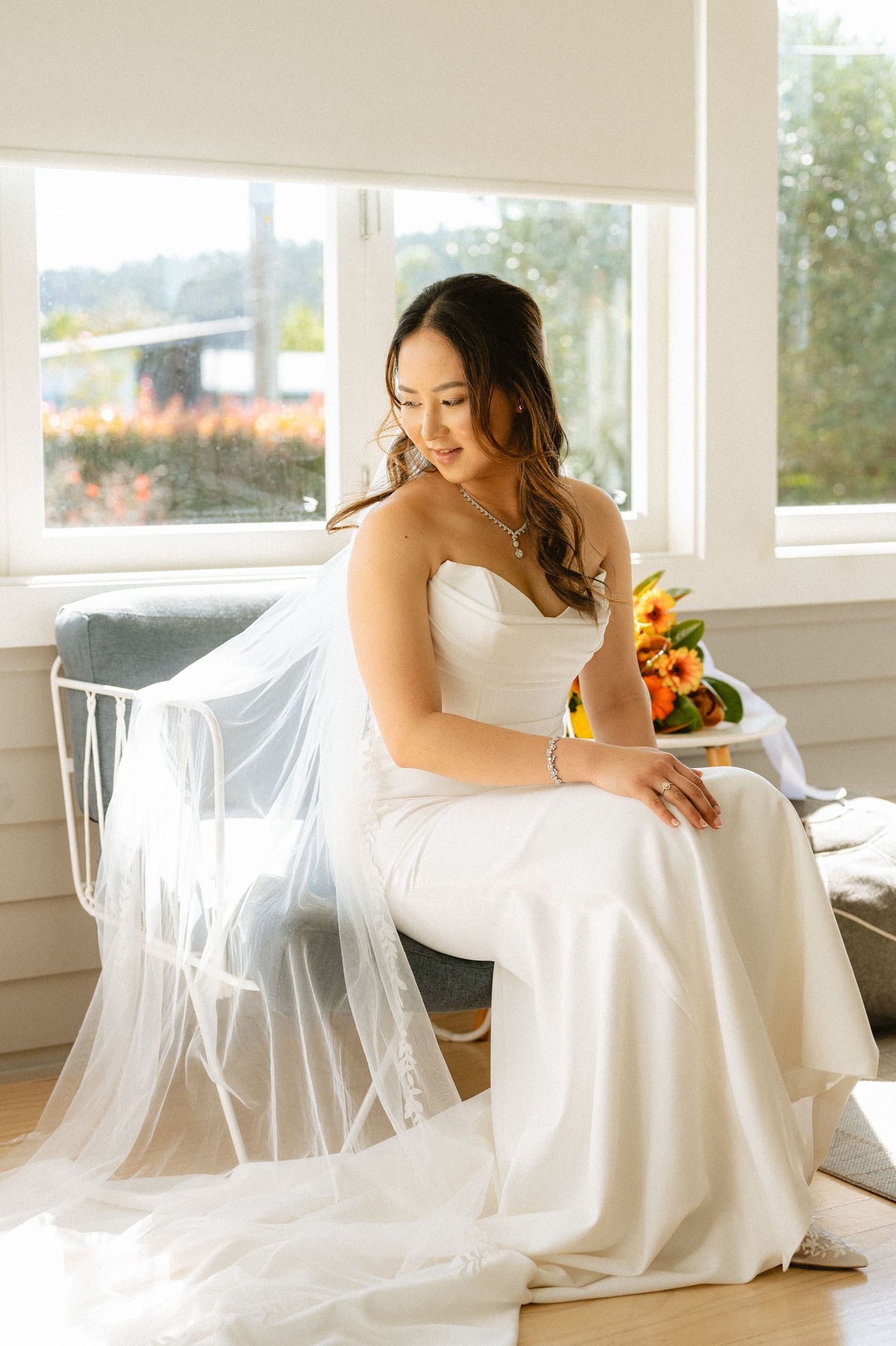 Ethereal bridal portraits in a bright sunlit room with white flowing fabric and sunflowers.