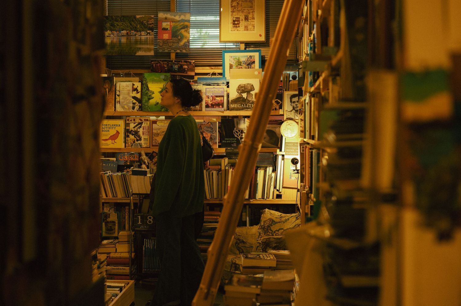 A girl walking through a vintage bookstore.