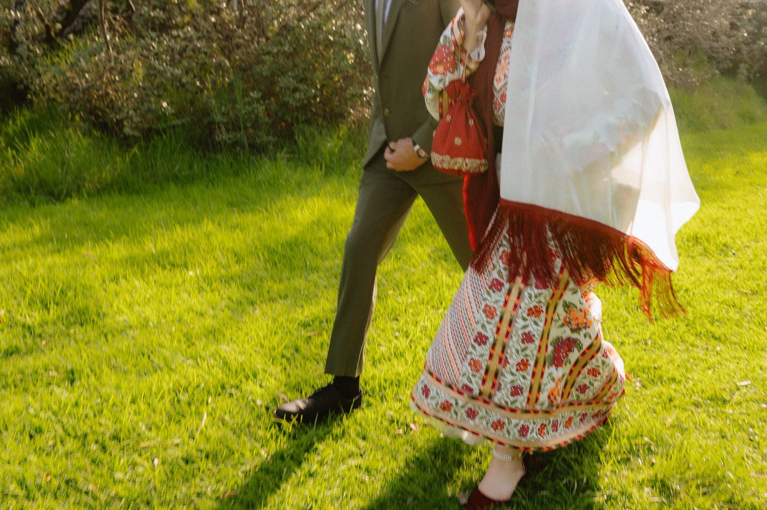 Wedding celebration with traditional ethnic attire in a sunny outdoor setting.