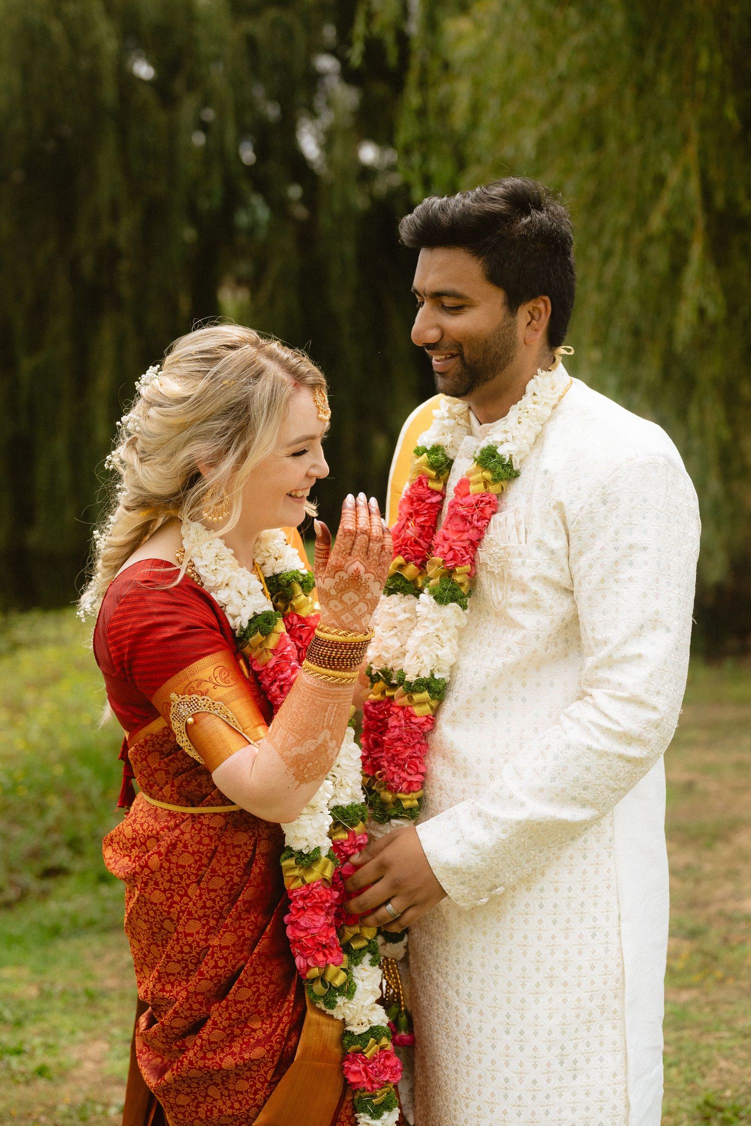 Cultural wedding celebration with couple in traditional attire and floral garlands.