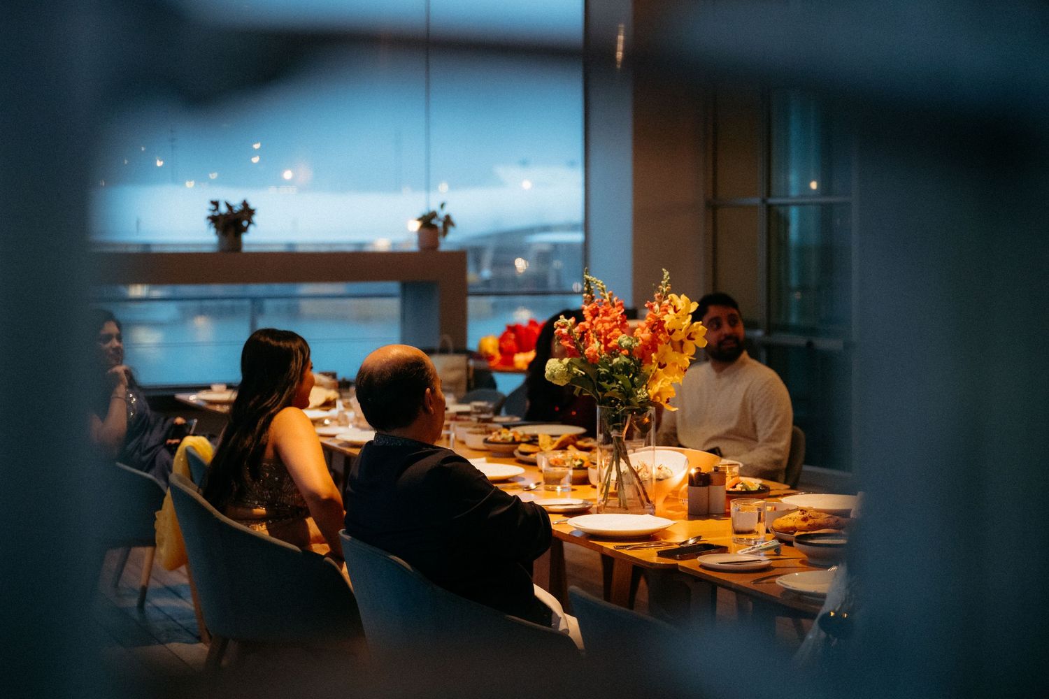 A dimly lit restaurant interior with soft lighting and elegant table settings creates an intimate dining atmosphere.