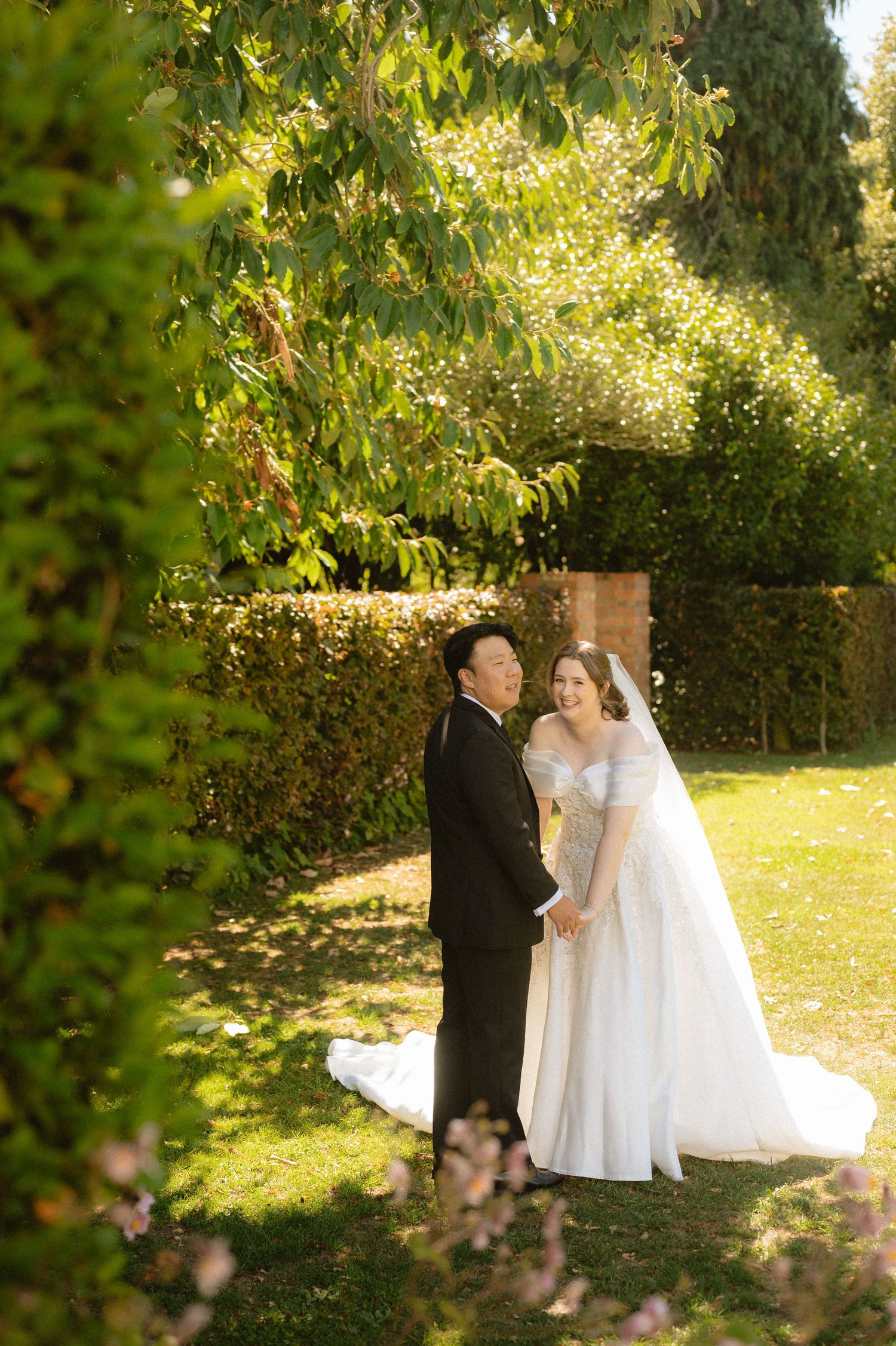 A romantic garden wedding ceremony sequence with a couple in white dress and dark suit under sunlit trees.