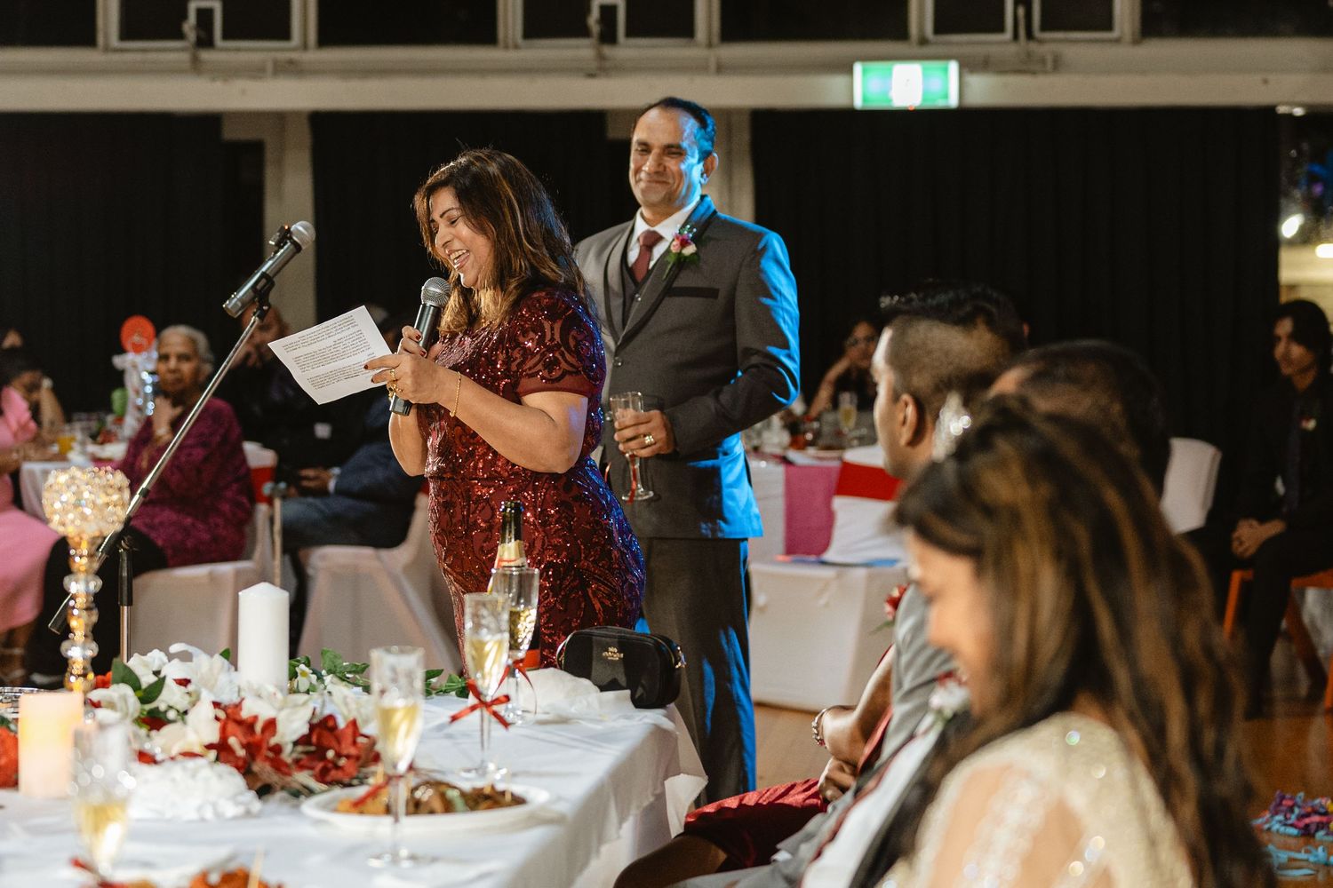 Man and woman giving a speech at a silver wedding celebration party.