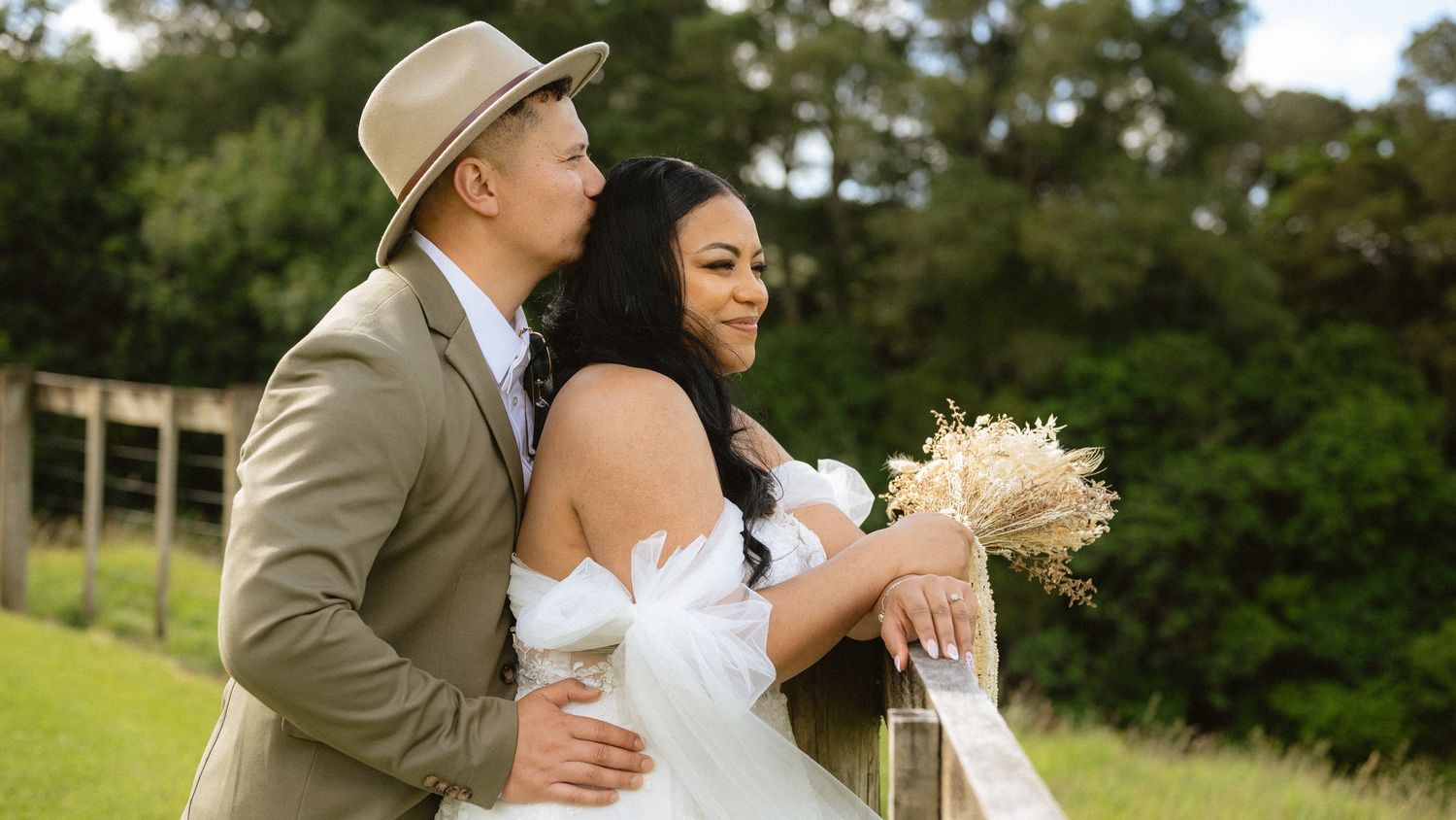 Wedding couple shares tender moments in an outdoor setting with natural greenery.