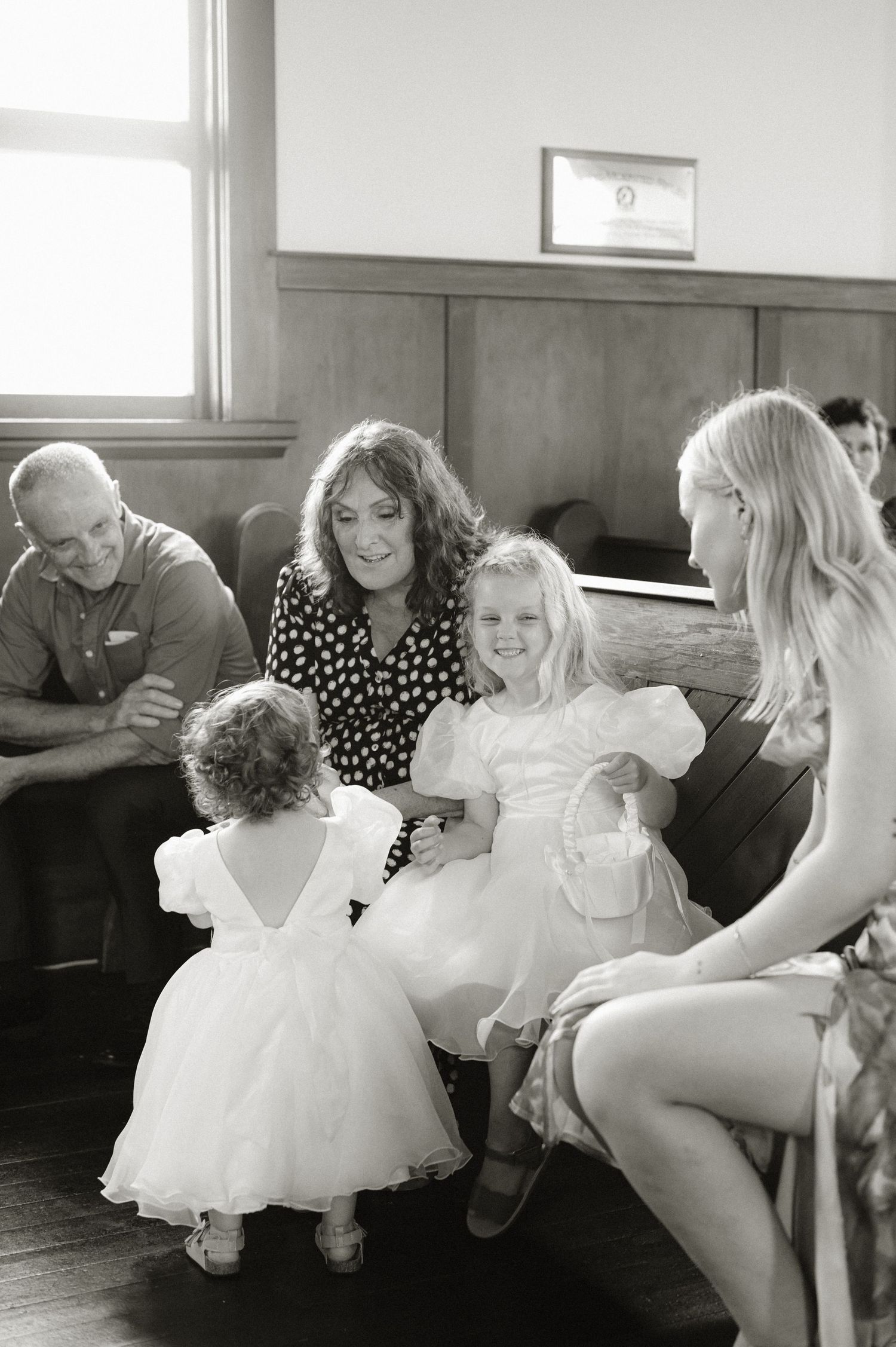 Wedding party members share joyful moments while getting ready in a bright indoor setting.