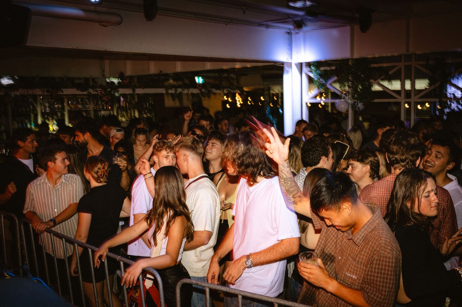Wide shot of the mosh pit with people dancing and head headbanging during a electronic music festival.