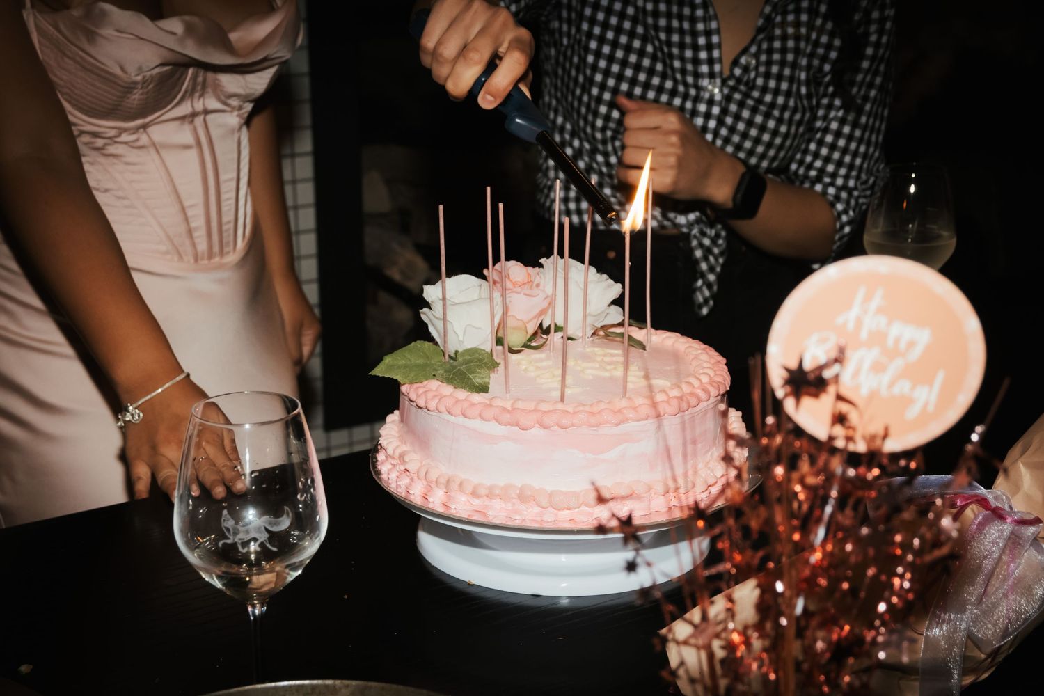 Pink 21st birthday cake being lit.