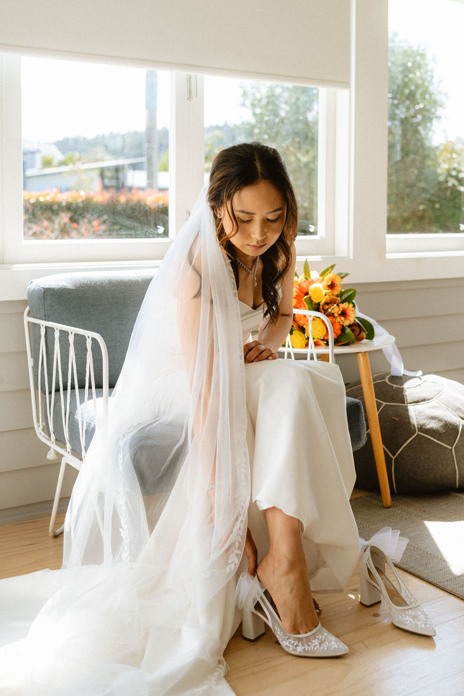 Ethereal Asian bride putting on her heels the morning of her wedding day