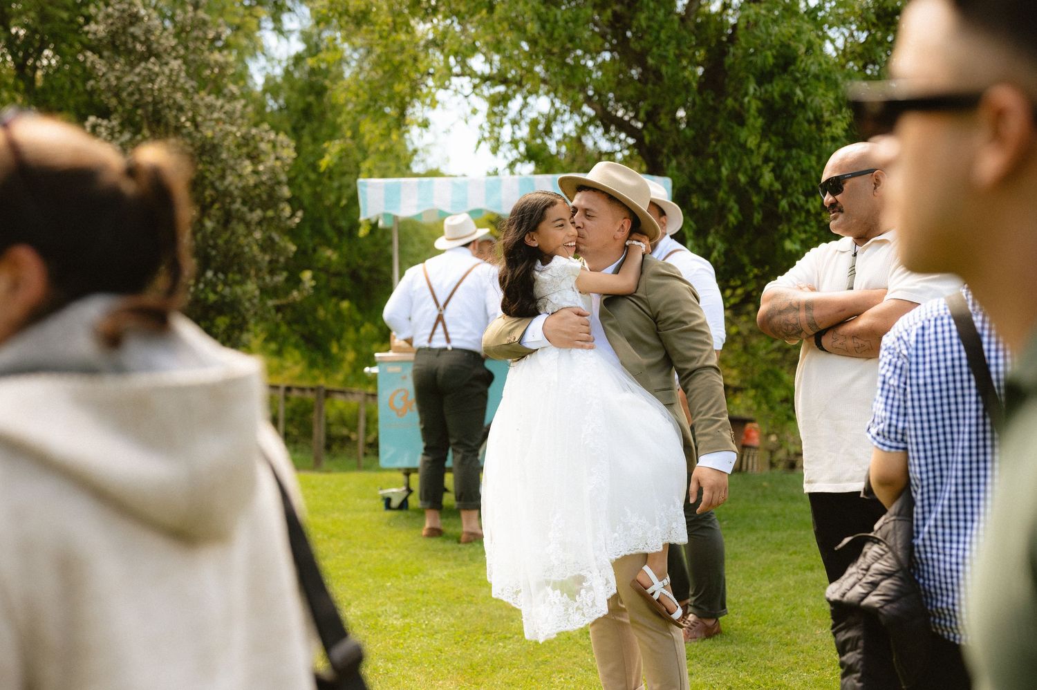 Candid wedding moments captured in a sunny outdoor garden setting.