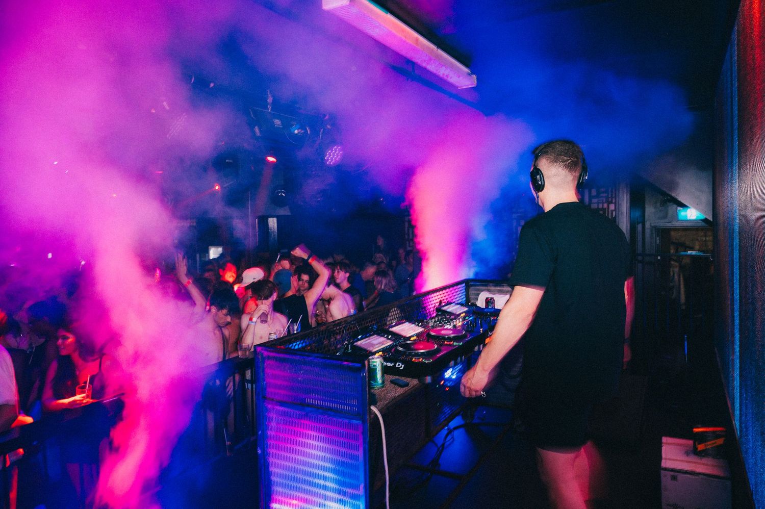 Nightclub scene with pink and blue lighting effects creating atmospheric ambiance.