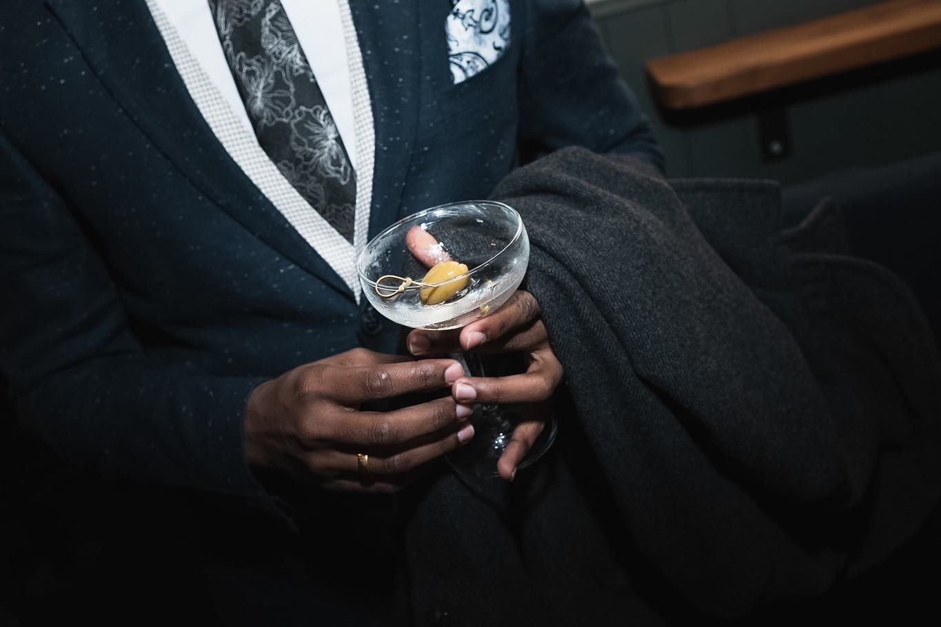 Man in suit holding a glass of martini.