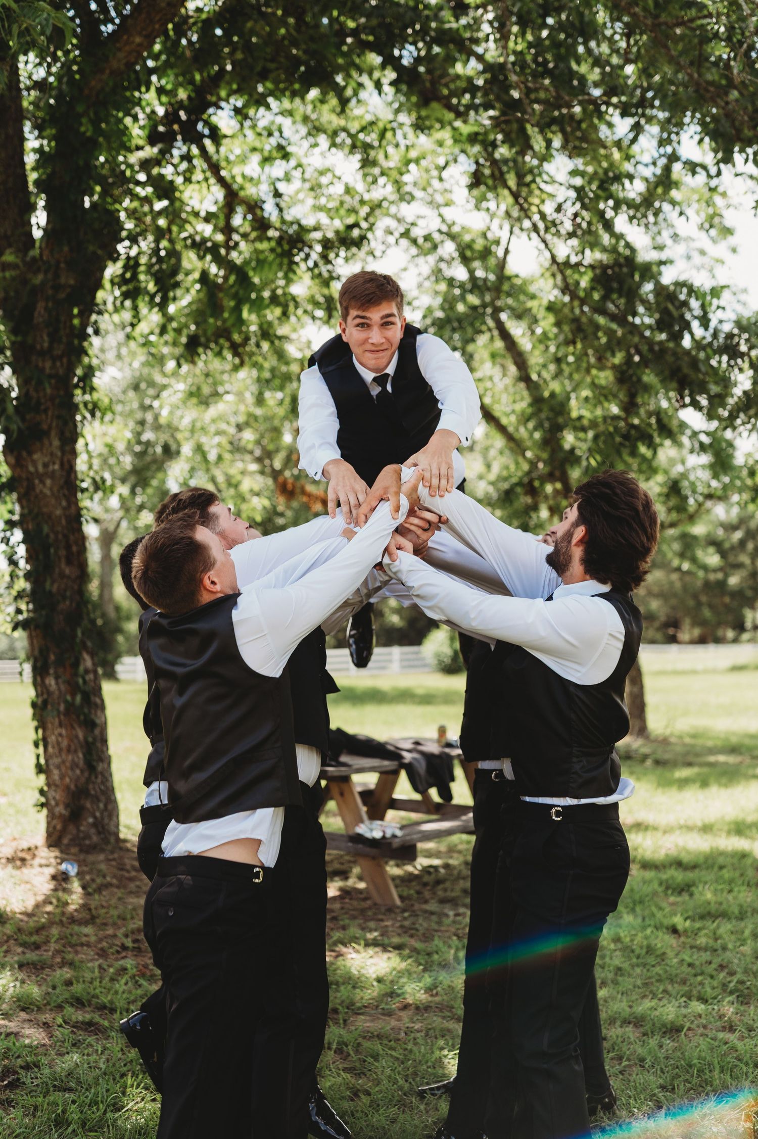 Groom celebrating with his groomsman outdoors on his wedding day | East Texas wedding photographer