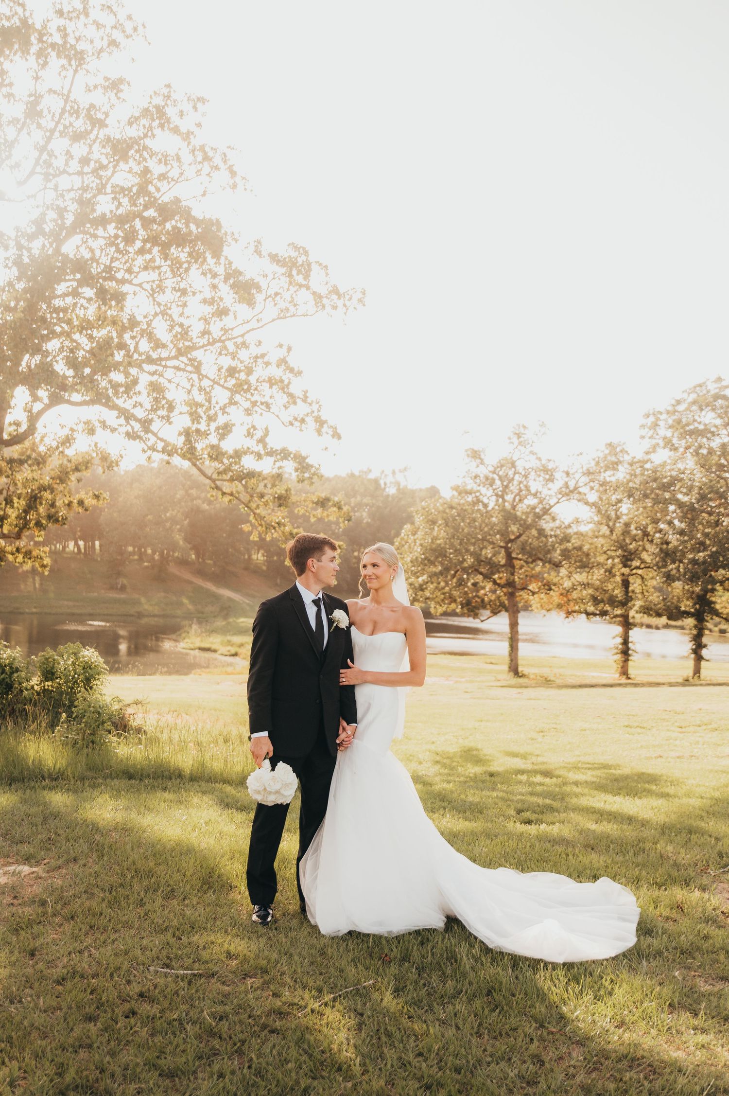 Bride and groom standing together outdoors in a sunlit field | East Texas wedding photography