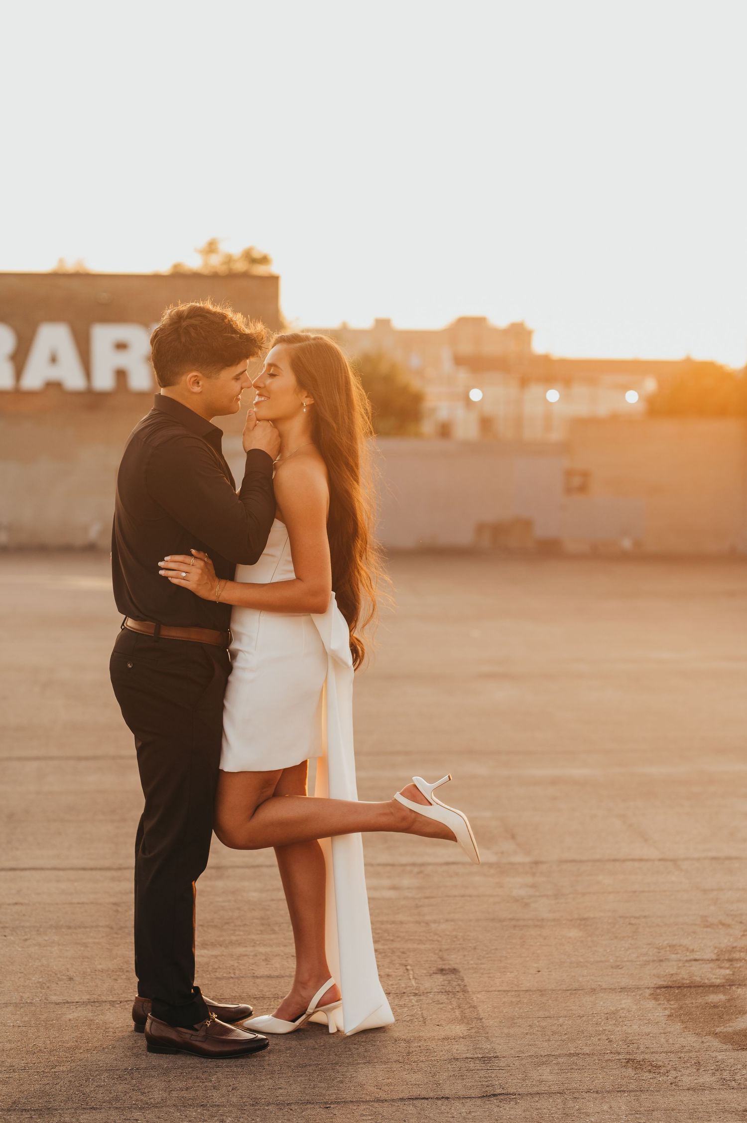 Couple embracing on a rooftop during a romantic engagement photography session in East Texas