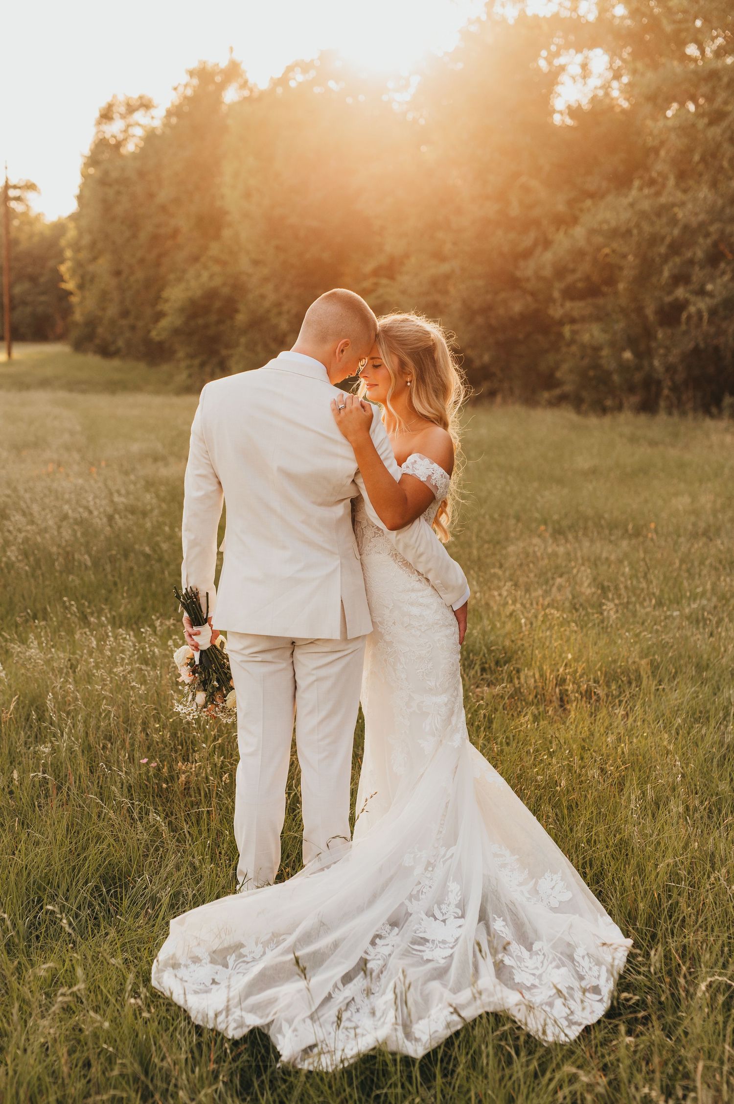 Newlywed couple embracing in a golden field during an East Texas wedding photography session.