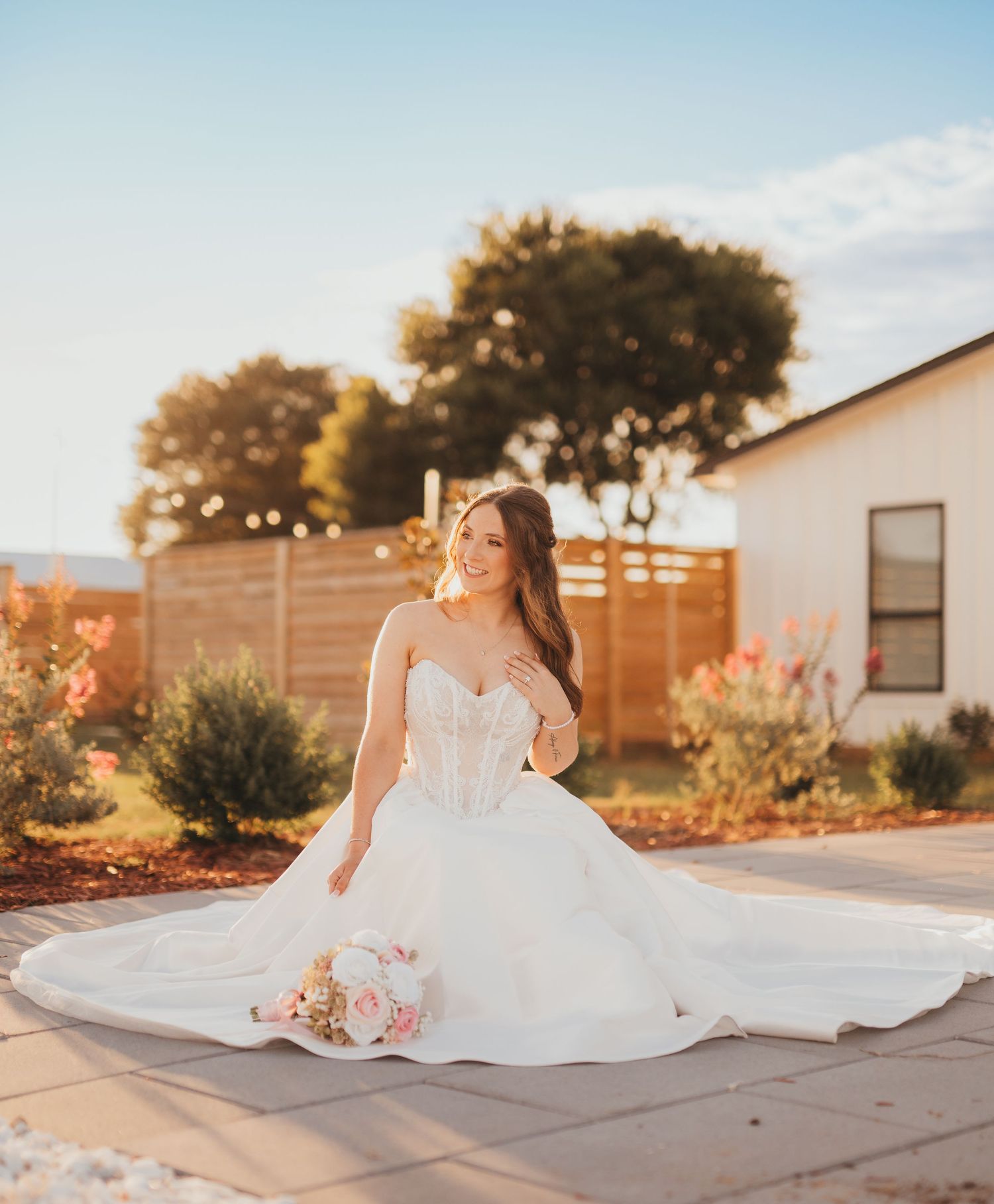Bride in wedding dress sitting outdoors infant of her wedding venue | East Texas wedding photographer