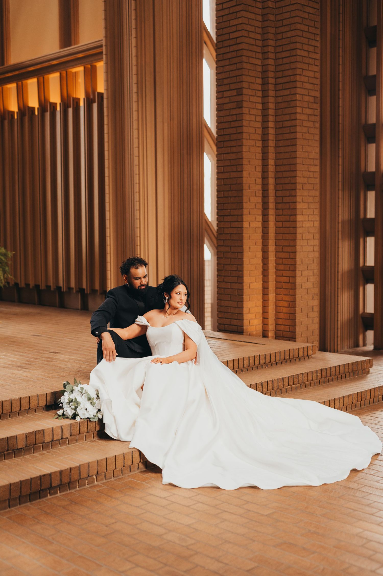 Bride in her wedding dress sitting on steps in wedding chapel | East Texas wedding photographer